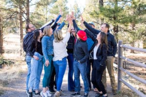 team members high fiving each other in the forest