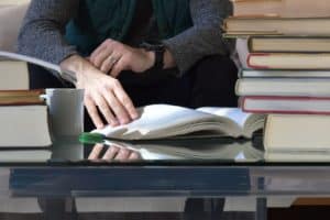person reading a book surrounded by books