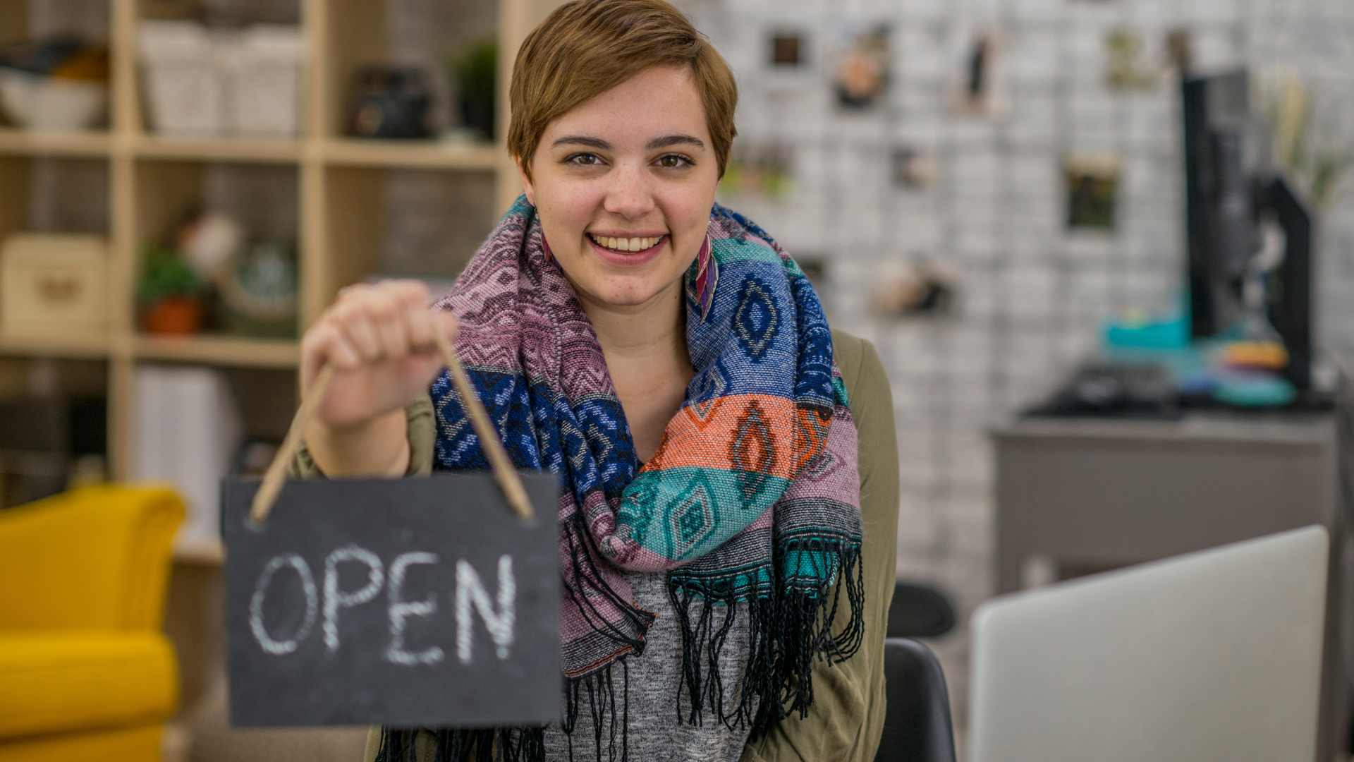 young entrepreneur holding an open sign