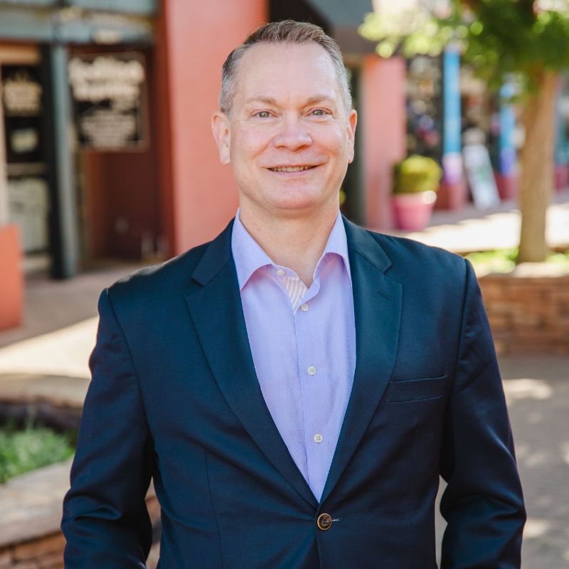 Ken is standing in front of shops in up-town Sedona.