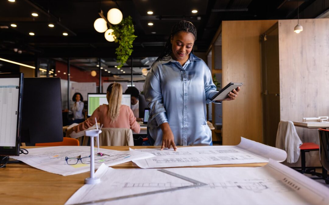 happy-plus-size-african-american-female-architect looking at plans on a table