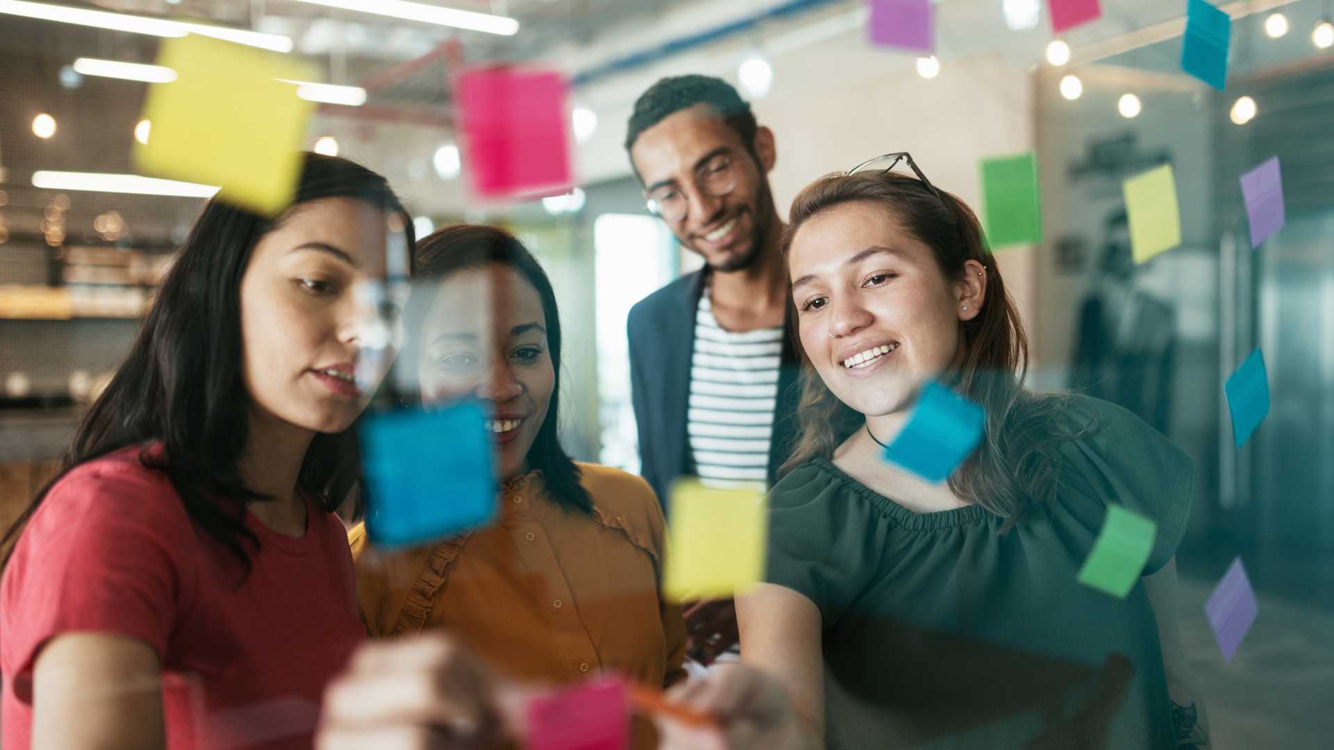 people looking at sticky notes on a wall