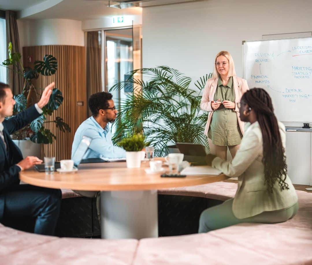 pregnant woman leading team meeting in pretty clean office