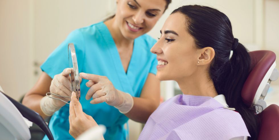 dentist showing patient smile in mirror