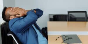 dentist at desk with hands on face in stress
