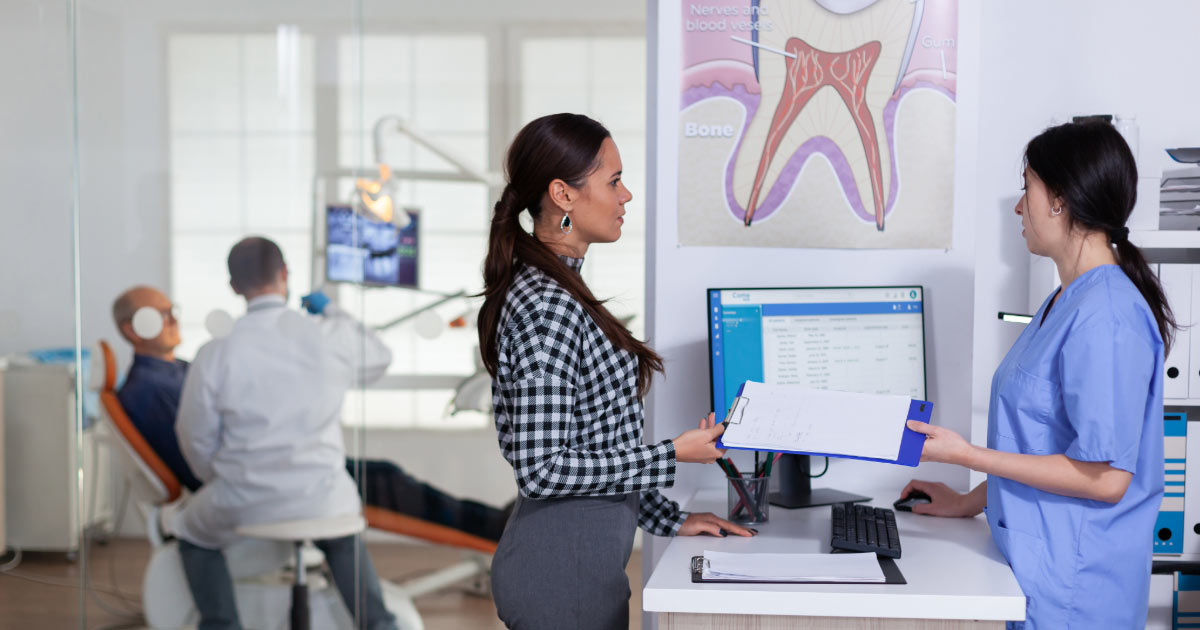 Modern dental office showing patient being cared for and another checking out