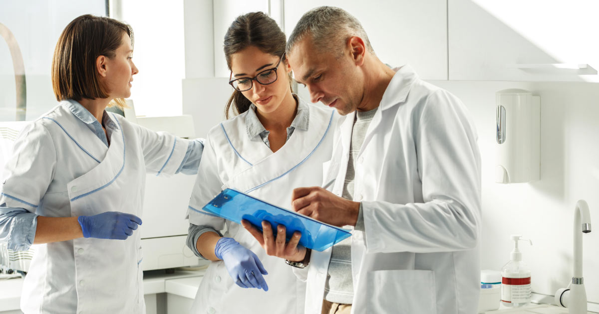 Dentist office owners reviewing location analytics while discussing growth