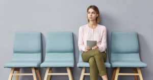 Single dental patient sitting in waiting room waiting for appointment
