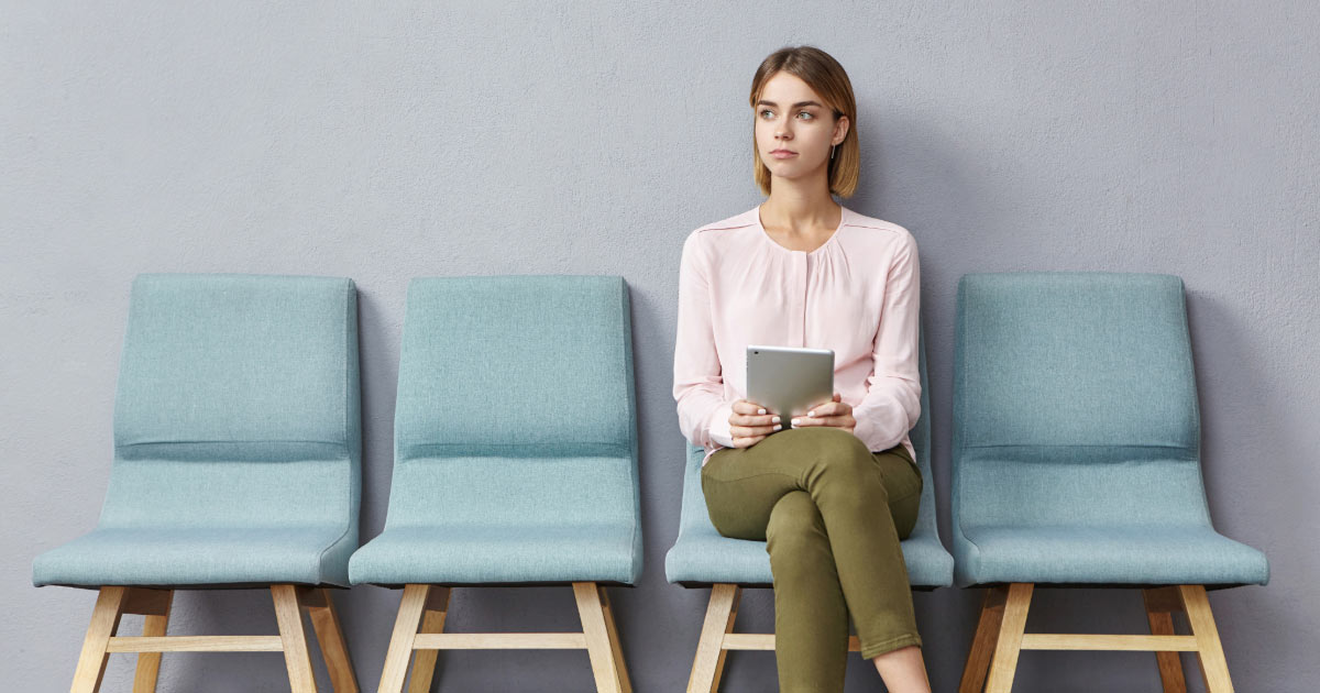 Single dental patient sitting in waiting room waiting for appointment