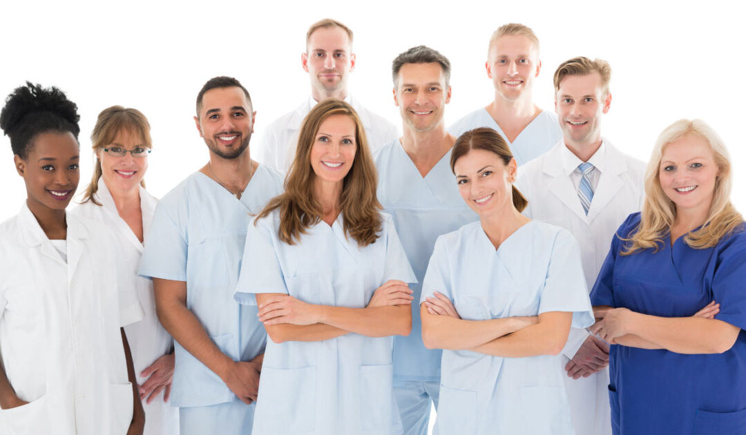 Group of 10 staff members at local dentist office posing for picture