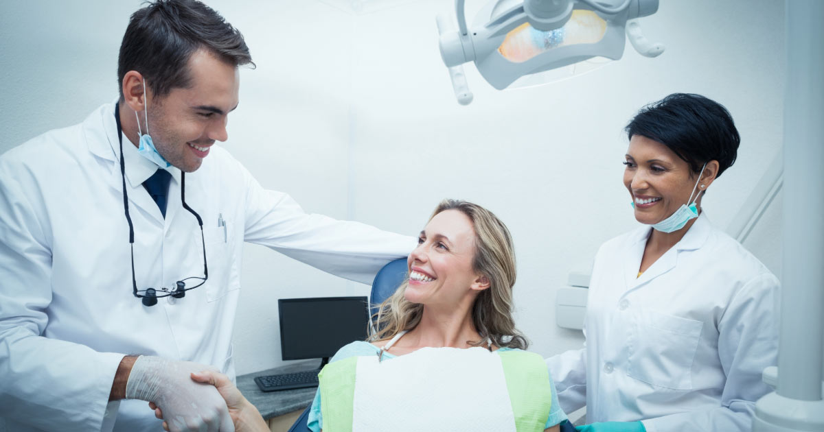 Woman sitting in dental chair meeting her dentist for the first time