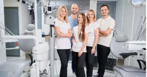Group of dental professionals standing in examination room
