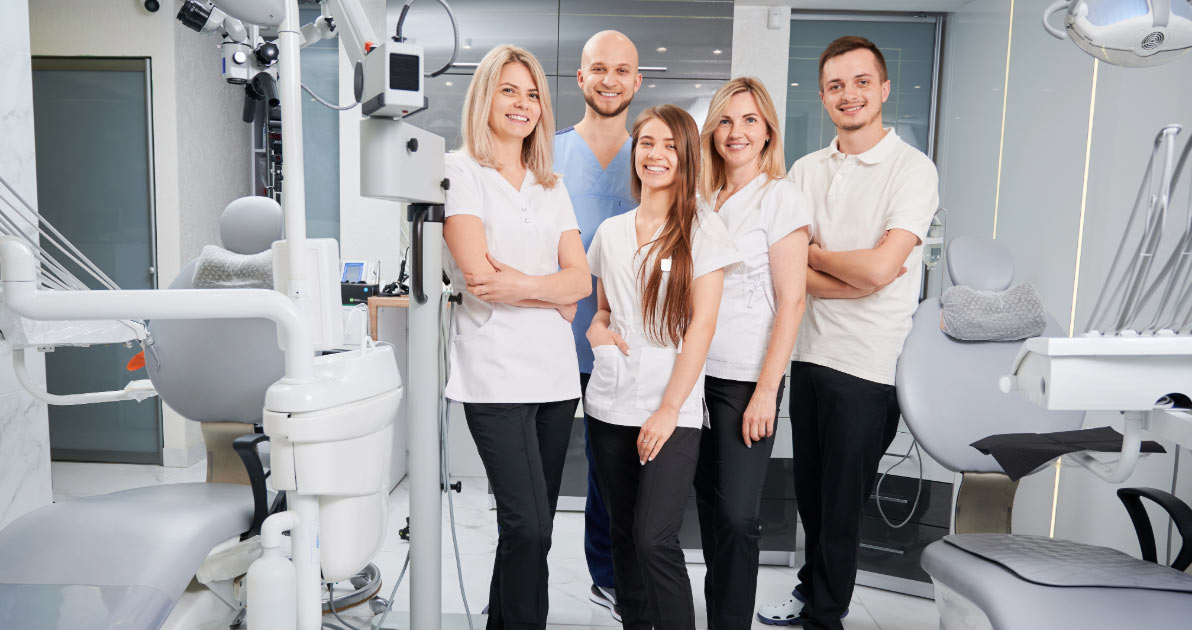 Group of dental professionals standing in examination room