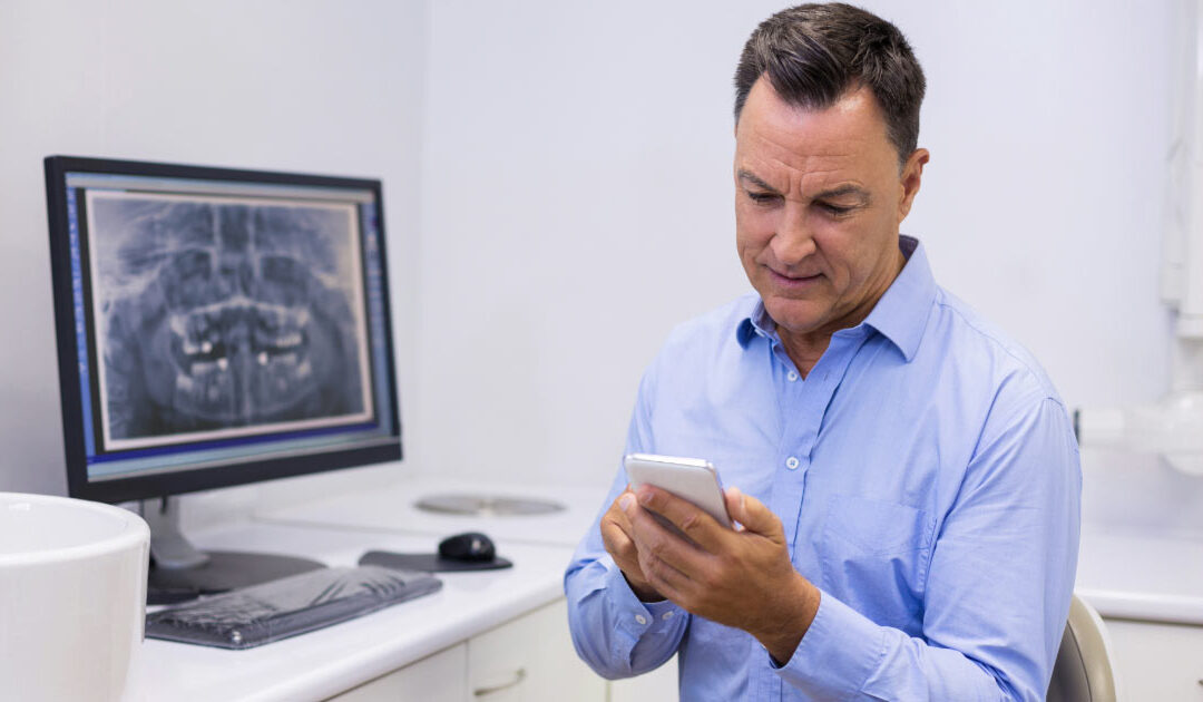 Middle-aged dentist in his office conducting business-related tasks