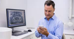 Middle-aged dentist in his office conducting business-related tasks