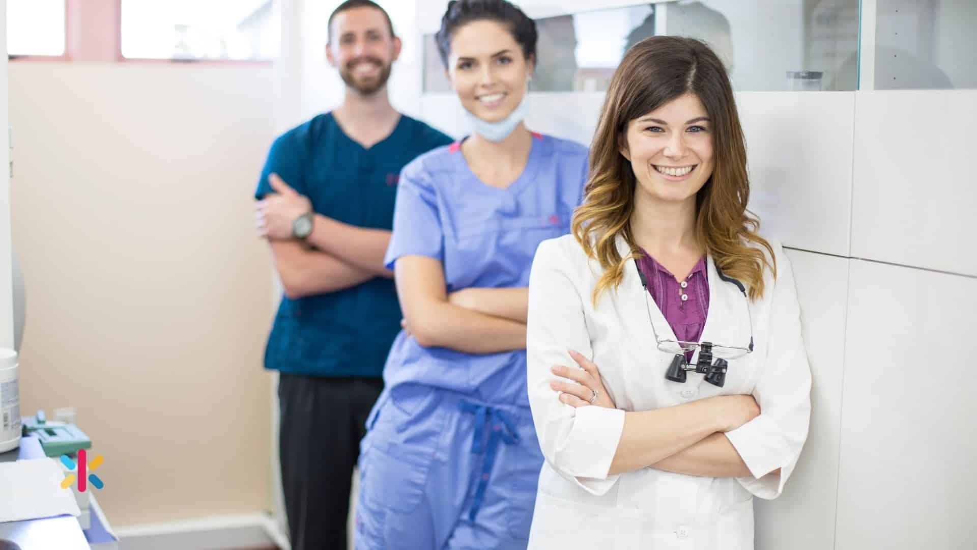Dentist standing confidently with dental team members in a modern dental practice.