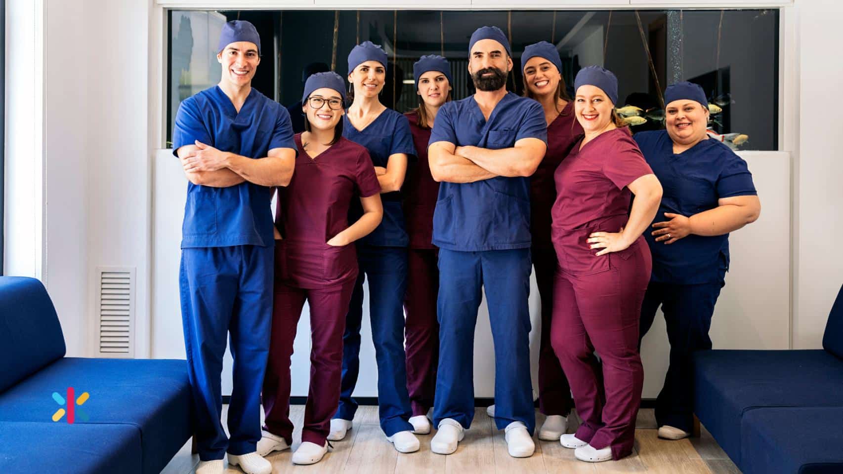 Dental practice team standing together in scrubs inside a modern dental clinic.