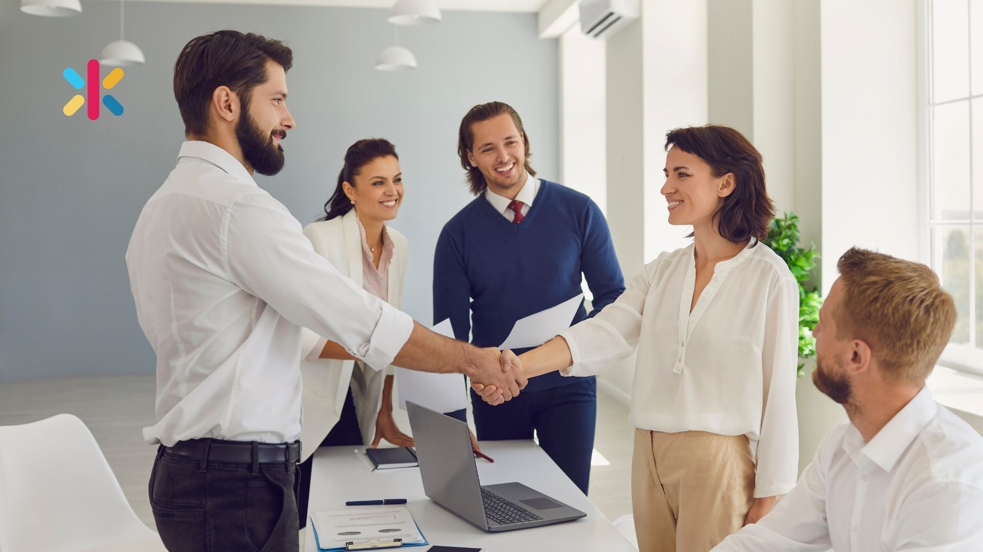 Promoting from within: a leader shaking hands with a team member during a team meeting